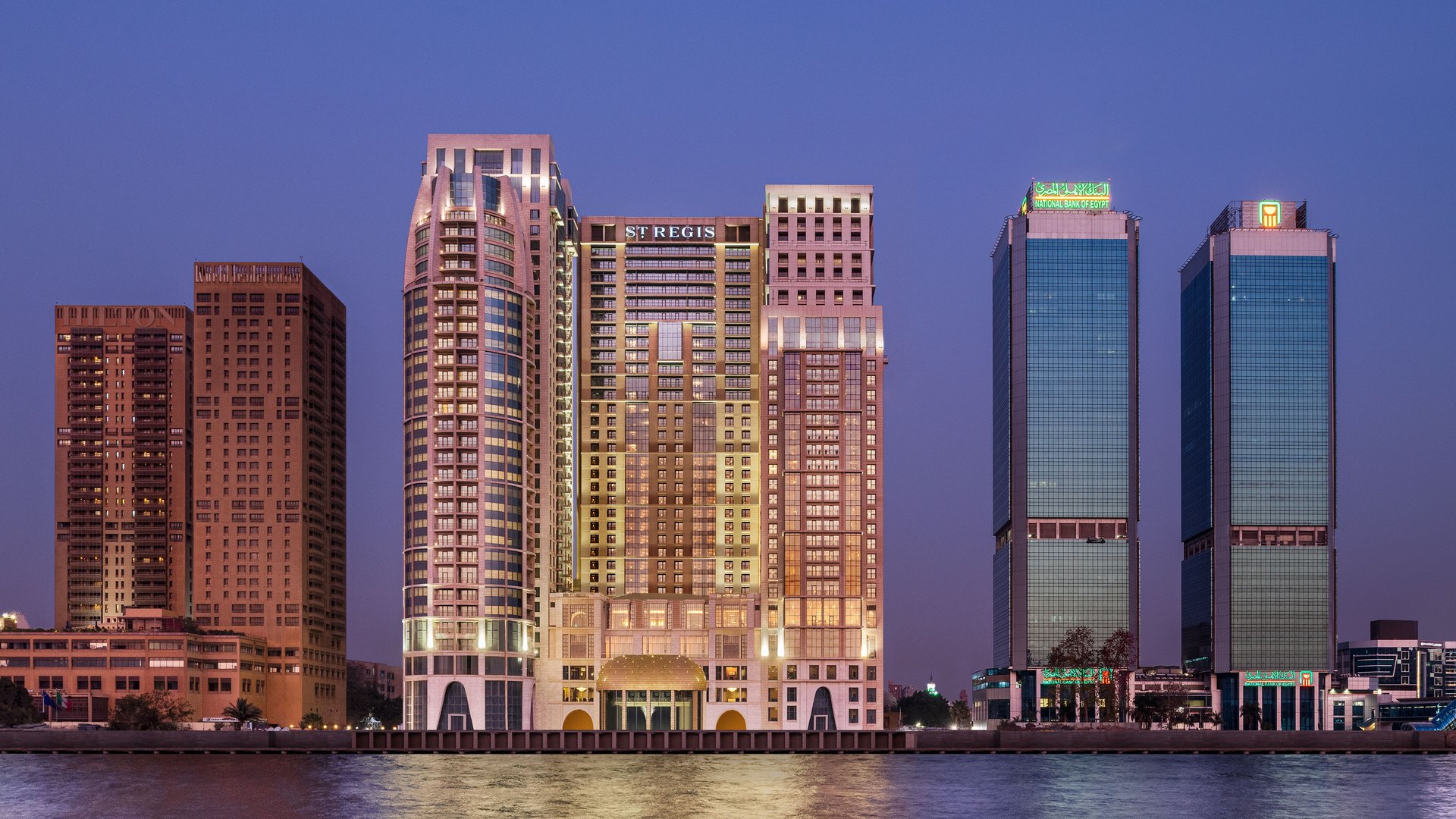 The St. Regis Cairo lit at dusk on the Nile Corniche
