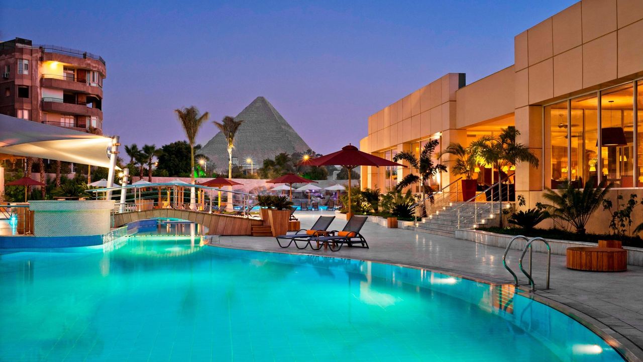 The pool of Le Méridien Pyramids at dusk, with the Great Pyramid beyond