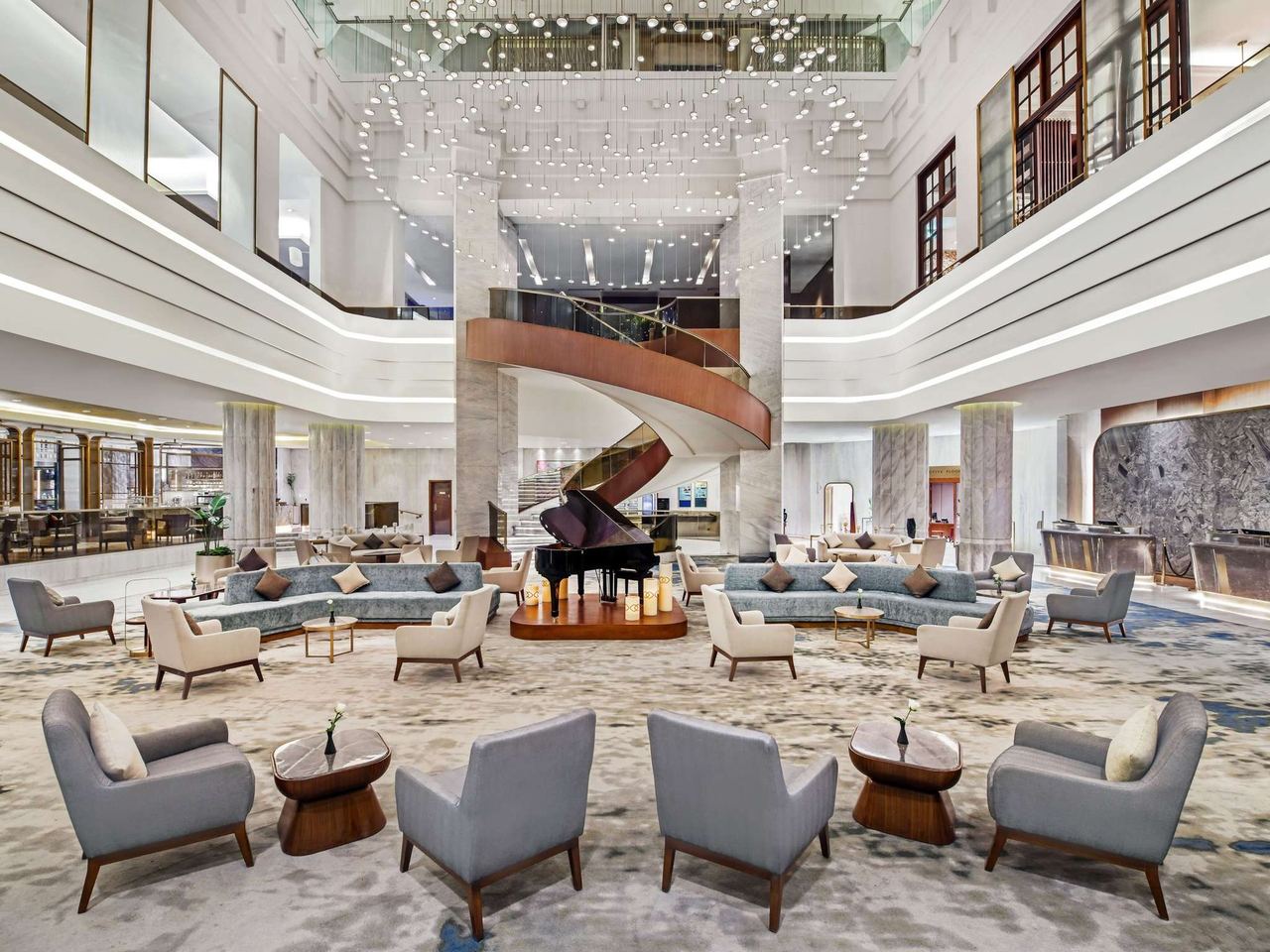 The atrium lobby of the Sofitel Cairo Downtown Nile, with its spiral stair and piano